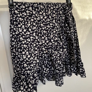 Kjol - Säljer denna söta kjolen med blommönster på i storlek xs. (Kjolen är mörk mörk blå). Endast använd fåtal gånger