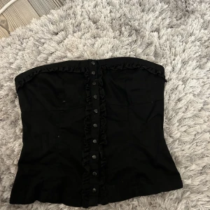 Svart topp - Säljer denna söta bandeau topp då den är för liten för mig:( den har fina detaljer och är i ett relativt tunt jeanstyg🤍kontakta mig gärna om du är intresserad