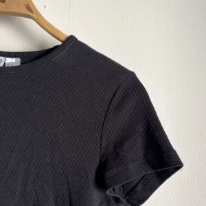 Svart topp - En svart kortare t-skirt. Säljer då den tyvärr inte kommer till användning