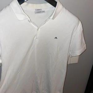 J.Lindeberg piké  - Vit j.Lindeberg piké i storlek L men passar även M. Bra skick.  Nypris:900. Mitt pris 299