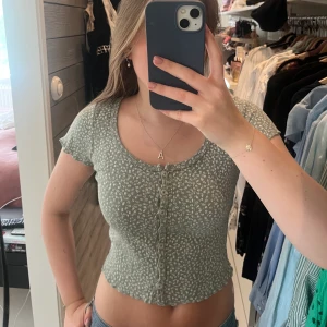 Grön topp från brandy Melville  - Säljer denna fina grönblommiga toppen från brandy Melville. Storlek onesize men skulle säga att den passar allt från xs till en liten m beroende på hur man vill att den ska sitta☺️☺️