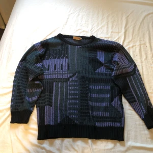 Lila/svart stickad tröja - Lila mönstrad stickad tröja i 70% akryl 30%ull alltså kliar den inget. I storlek XL men passar mindre jag har storlek s/m och passar på mig.