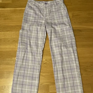 Ljuslila rutig byxa från HM - Ljuslila rutiga byxor med stora fickor från HM i storlek 34. Säljer då de är för långa.
