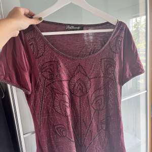 Lila/vinröd glittrig tröja med mönster på framsidan, köpt second hand, strl S
