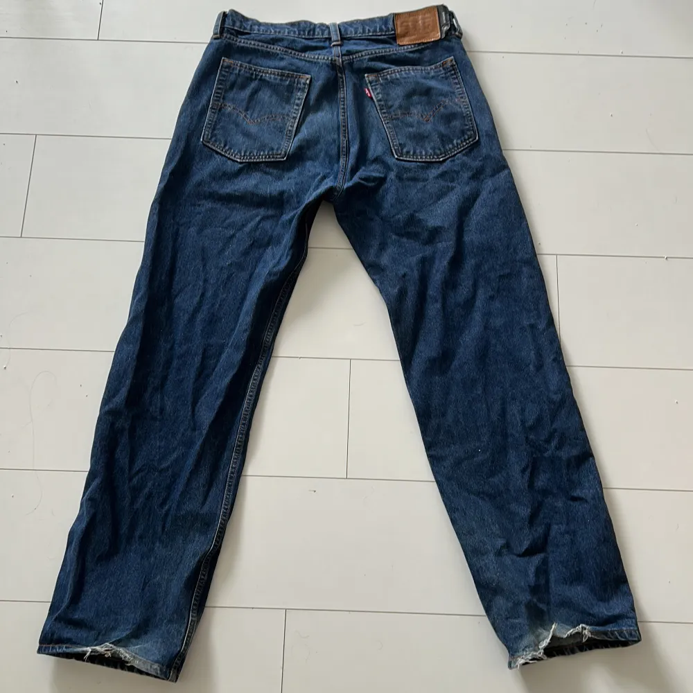 Mörkblåa baggy Levi jeans. Rivet vid hälarna men utöver i bra skick. Storlek: 33/34. Jeans & Byxor.