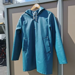 Stutterheim regnjacka - Stockholm Raincoat. Inköpt 2018 och är i bra skick.  Ursprungspris: 2500 kr En regnjacka med rak passform i kraftigt och slitstarkt vattentätt tyg. Experttillverkad, den är skräddarsydd med dubbelsvetsade sömmar.  