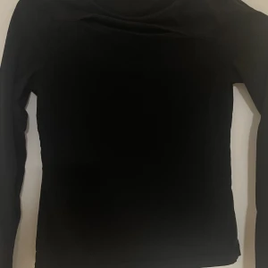 Svart långärmad tröja  - Svaren långärmad tröja med hål där framme super häftig tröja som blivit använd ett fåtal gånger då den varit för liten för mig. Tröjan är i stl 158/164 men har också en i storlek mindre så gå in o checka på den.Tröjan är köpt för 170kr och passar med allt