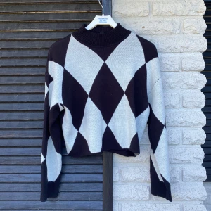 Stickad tröja  - En svart/vit stickad tröja i mycket bra skick. Den har även en lite längre hals.  