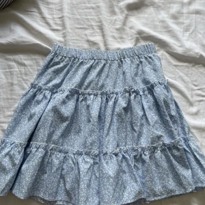 Kjol - Ljusblå blommog kjol som ej kommer till användning 