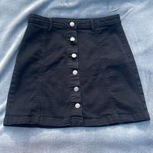 Svart kjol från Gina tricot med silvriga knappar 
