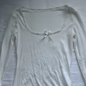 långärmad ribbad tröja med rosett - väldigt smickrande och fin topp! använd endast 2 ggr. obs rosetten är lite missplacerad 