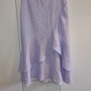 Lilaprickig volangkjol NA-KD - Lilaprickig volangkjol från NA-KD. Storlek 40. Endast använd 1 gång