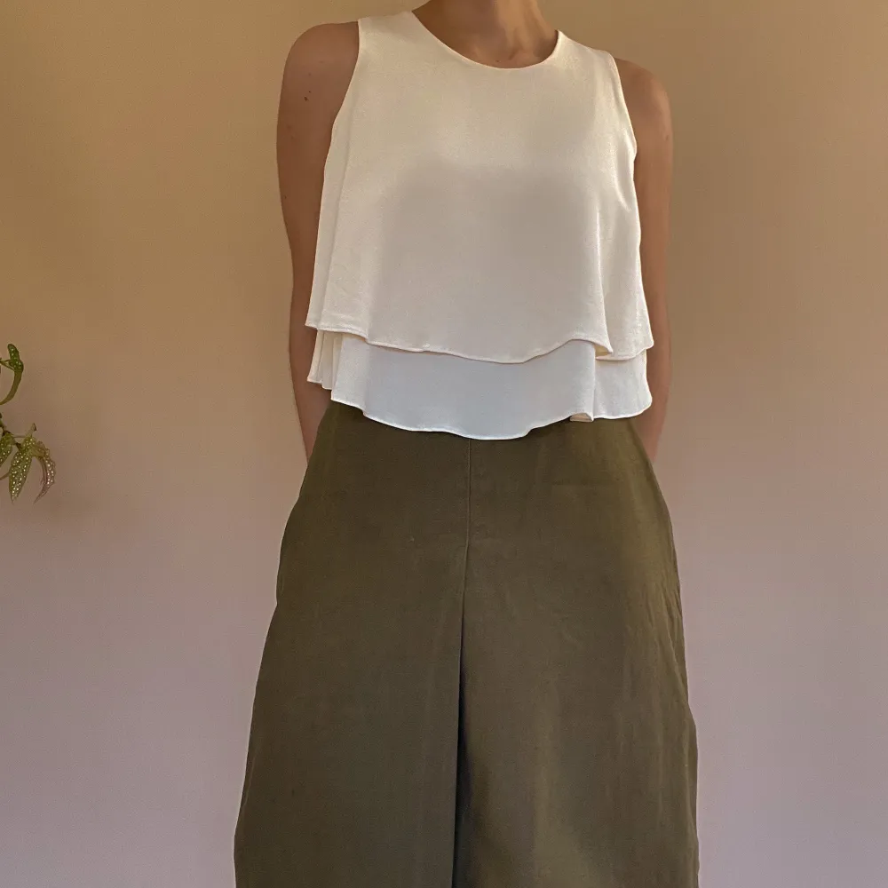 Flowy Silk Tank with Double Skirted Hem. Single Button Closure in Back. Made with Deadstock Designer Heavy Silk Fabric. Excellent Condition. Model is 160cm (5”3) and generally fits XS/S. 40 CM/ 15.7 IN Length 28 CM/ 11 IN Shoulders 76 CM/ 29.9 IN Chest. Puserot.