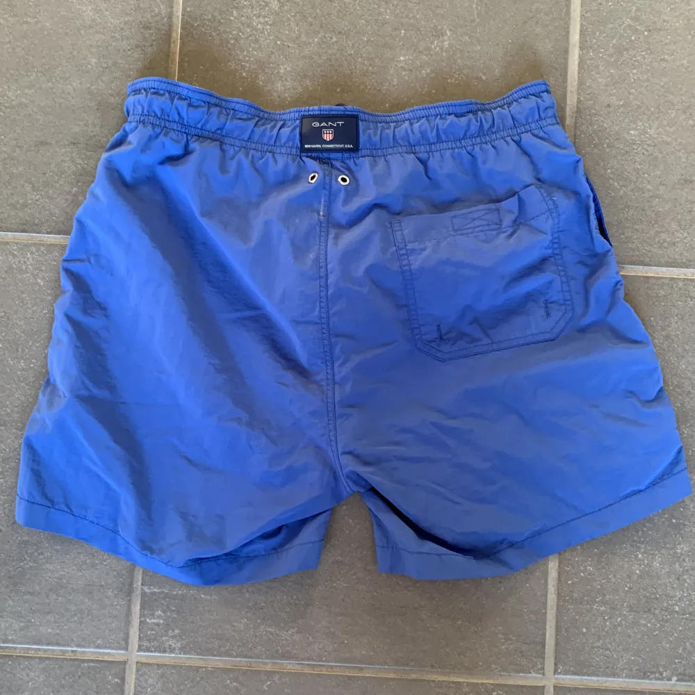 Ett par blå snygga Gant badbyxor som jag säljer för dom har blivit för små för mig. Det är en liten ”repa” på baksidan som knappt syns. Det finns 2 framfickor och en bakficka. Shorts.