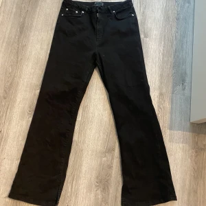 Jeans Asos - Svarta jeans från asos i storlek 32/28 petite . Jeansen har slits längst ner på bena och är använd ett fåtal gånger. 