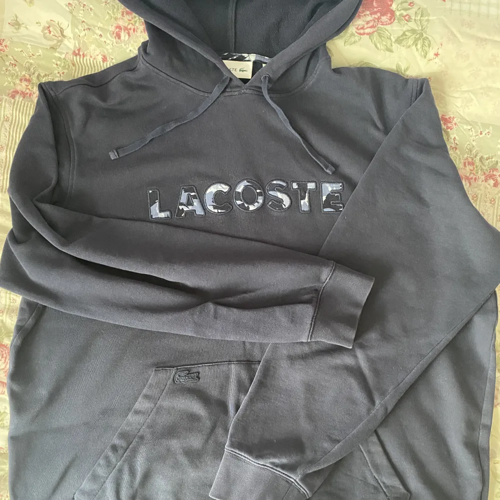 Hej, säljer den här fina äkta Lacoste hoodie. Vet ej hur gammal den är men dens kvalite är som gott som ny! Den passar som En L!🫶🏼. Hoodies.