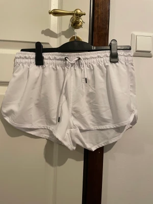 Shorts - Vita shorts i något skumt material, som en träningsjacks typ med snörning
