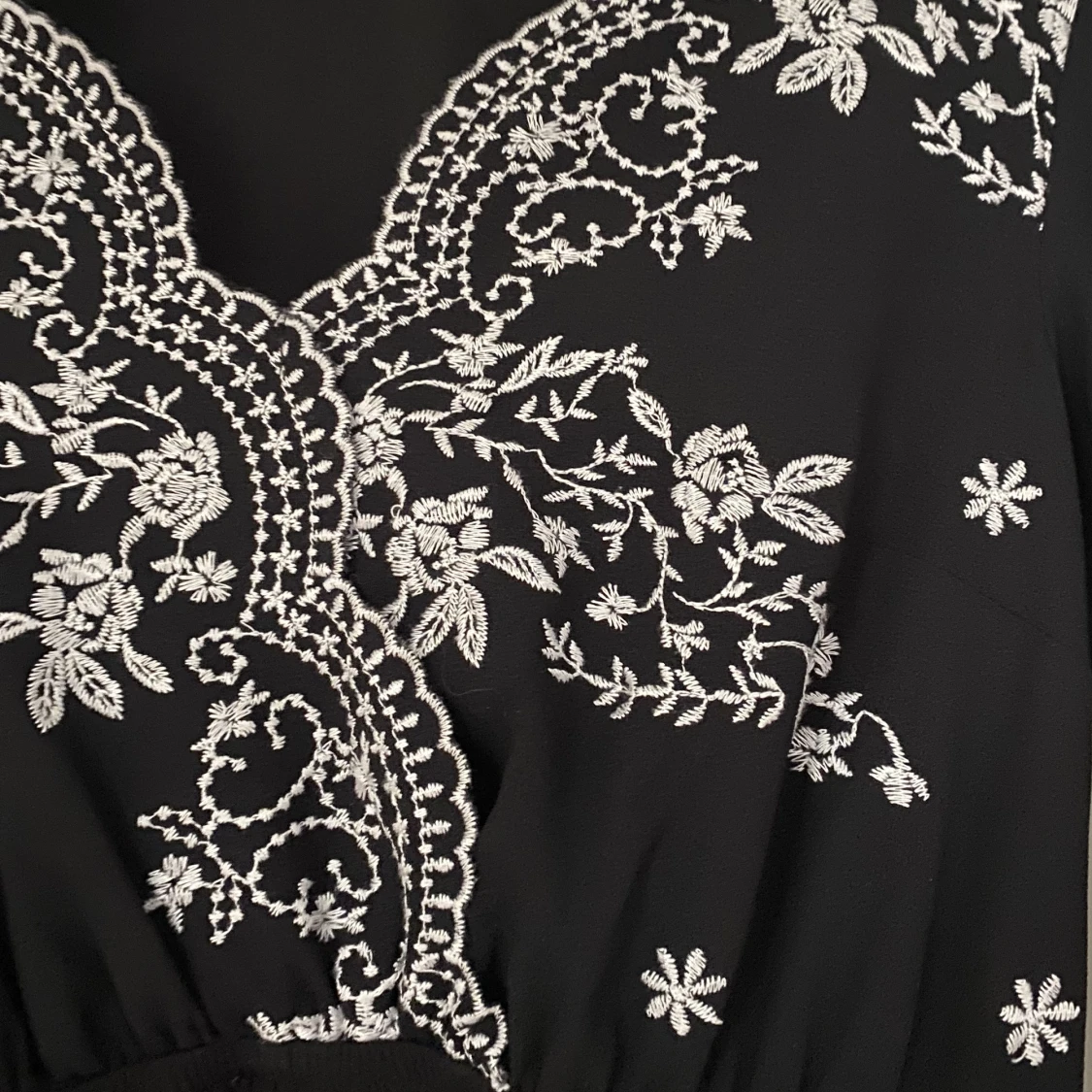 Svart klänning med vita broderier - 90