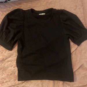 Svart puffärmad t-shirt - Fin t-shirt som inte kommit till användning. inga defekter. Storlek xs men passar också större storlekar då den är lite stor i storleken!