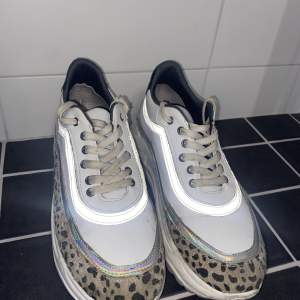 Snygga sneakers med reflex och leopard mönster. Väl använda men i fint skick. En liten spricka bak i ena stötdämparen, vilket syns på ena bilden men ytterst litet. Storlek 39. Belle shoes.