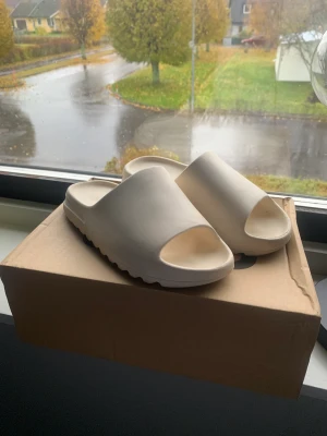 Yeezy slides  - Säljer min yeezy slides nu går ej i dom längre användt ett par gånger fast bara inomhus box följer med och tofflorna är i storlek 39