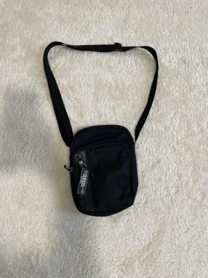 Nike väska - Jag har en snygg Nike axelväska till försäljning för endast 150 kr. Jag köpte den från Zalando, och den är i utmärkt skick utan några skador eller fläckar. Ett bra erbjudande!