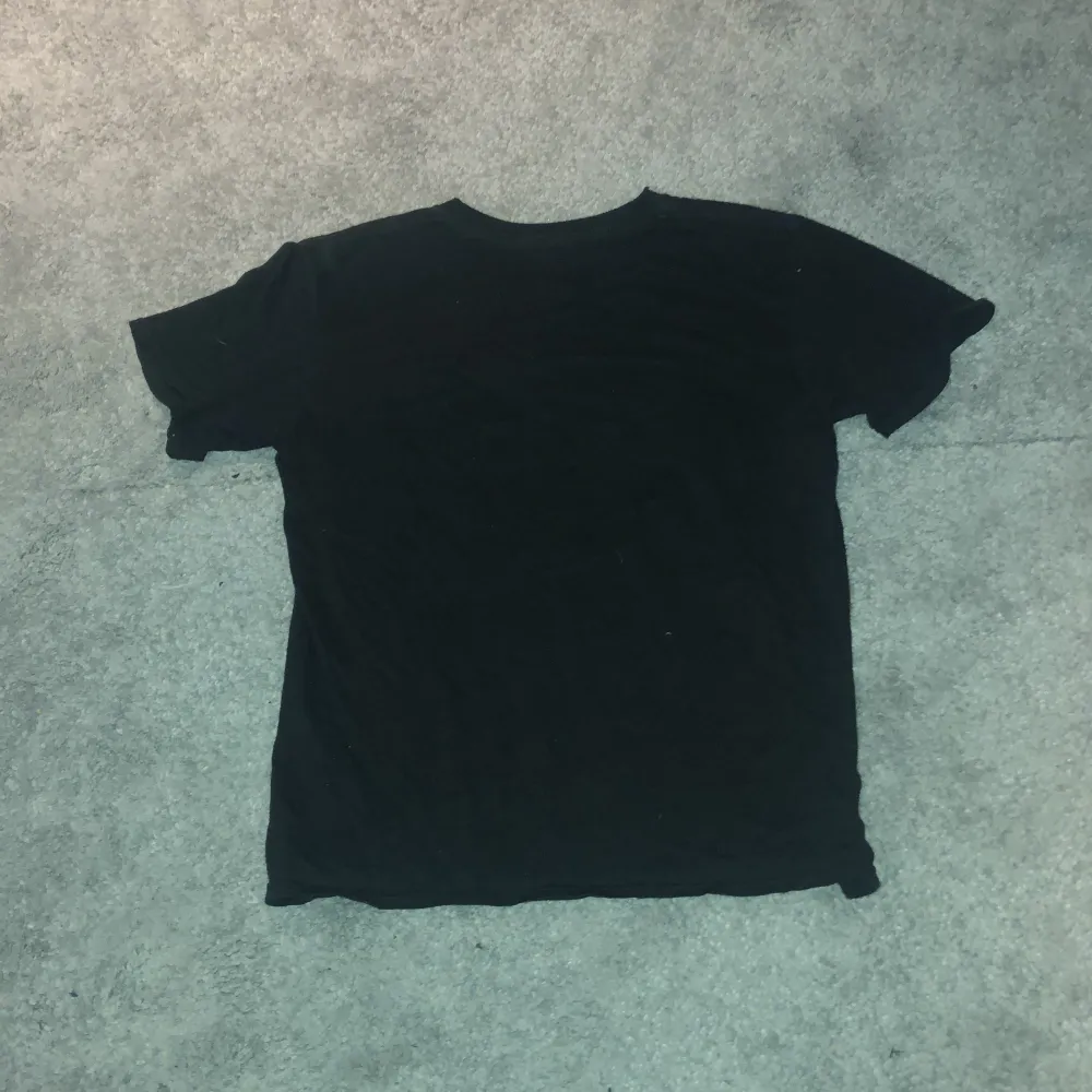 En svart t-shirt med ett tupac tryck på framsidan. T-shirts.