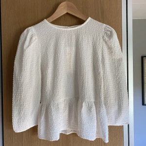Vit topp med volang  - Vit topp med volang nertill, 3/4 ärm, ursprungligen från ONLY, prislapp kvar, nypris: 400kr