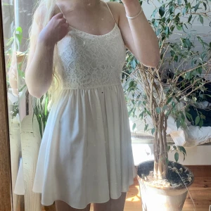 Vit klänning  - Vit klänning med spetsblommor. Sparsamt använd så i bra skick. Superfin till sommaren, dock lite genomskinlig. 🤍