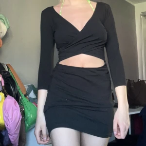 Svart klänning  - En jättefin svart klänning från Nelly  som är öppen vid magen
