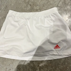 Tenniskjol adidas - Säljer denna fina tenniskjol från adidas, använd ett gäng gånger men inte så mycket. Strl 152 men skulle säga ungefär xs. 