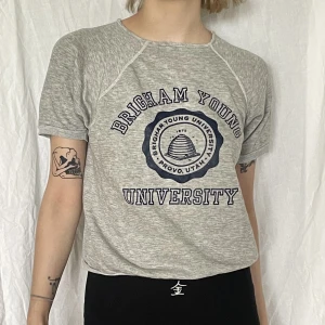 Grå mysig t-shirt med tryck - Grå t-shirt med universitetet logga på, ganska tjock material men ändå inte. Går upp till midjan ungefär 