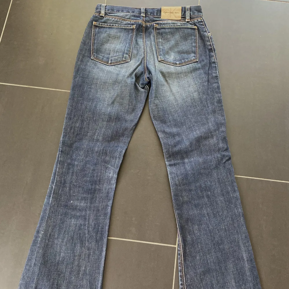 Säljer dessa lågmidjade bootcut jeans från calvin klein. (Sömmen har gått upp lite på ena sidan vilket man kan se på bild 2.). Jeans & Byxor.
