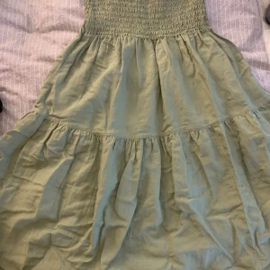 Lång grön kjol - Lång kjol funkar även som klänning. Bekvämt material. Finns tyvärr en färg fläck långt nere på kjolen men annars bra skick