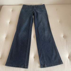 Vintage lågmidjade wrangler jeans med vida ben. Storlek w28l34. Yttre mått 108 cm, innerbensmått 90 cm, midjemått rakt över 38 cm. Mycket fint skick, något slitna längst ner. 