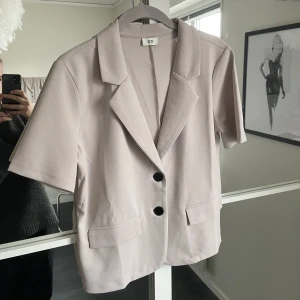 Kavaj  - En beige kavaj i t-shirt form från Nelly.com. Jättefin och helt ny, aldrig använd.  Köparen står för priset + frakten🖤