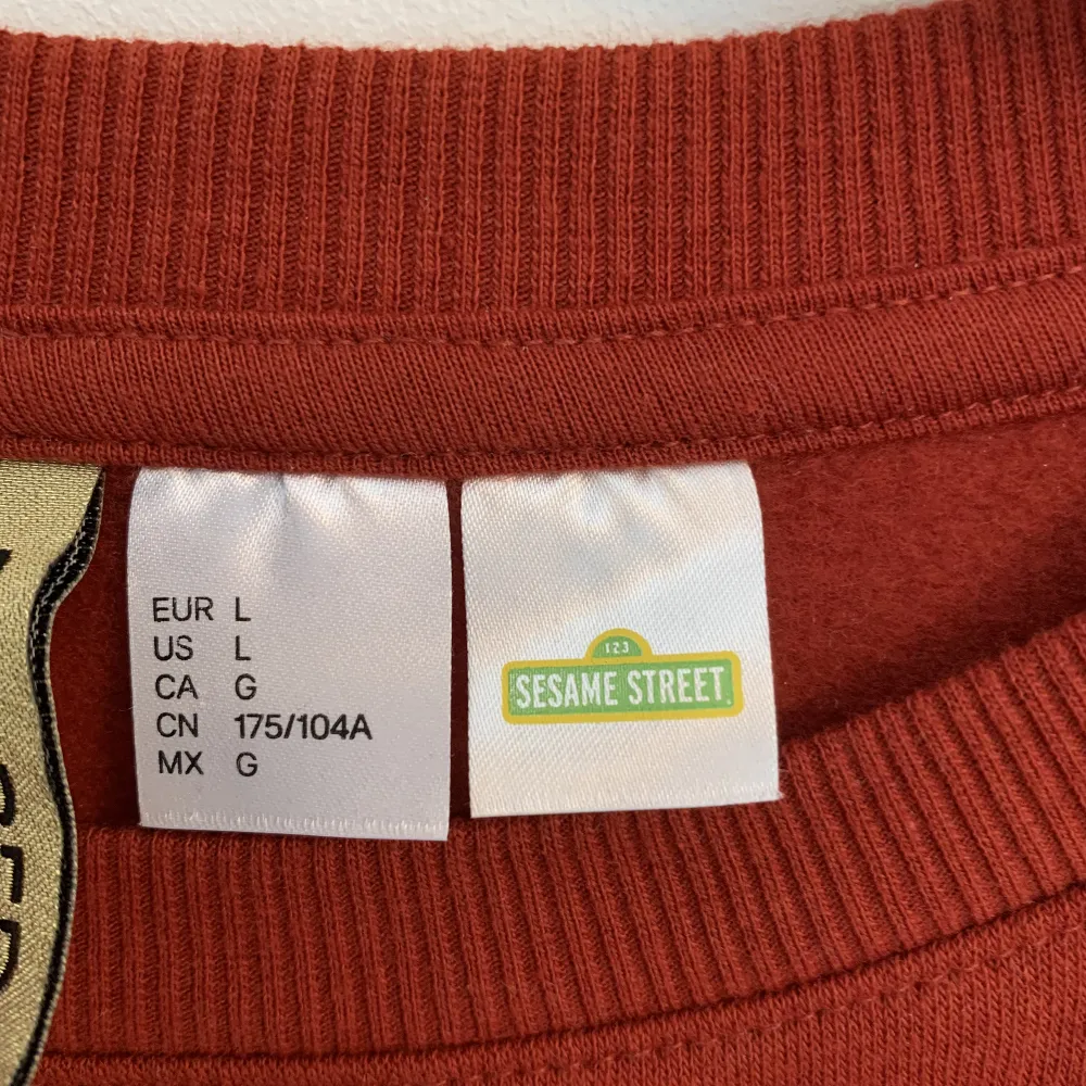Ny, oanvänd, croppad, Elmo sweatshirt från H&M Divided i storlek L.  Sweatshirten är tegelröd.. Tröjor & Koftor.