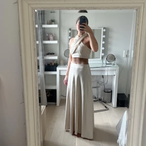 Krämvit/beige långkjol - Krämvit/beige supervacker långkjol med fint fall i satin. Aldrig använd, prislapp kvar. Nypris 600kr, mitt pris 300kr ☺️