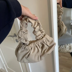 Handväska - Söt beige handväska ifrån nakd. Magnetstängning och flera fickor inuti.