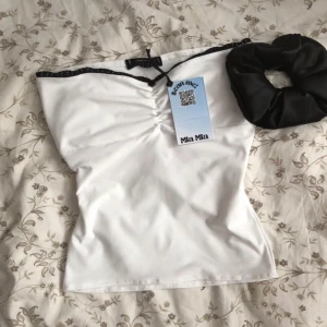 Tubetop - Säljer denna vita Tubtopp i storlek s. Den har svart spets detalj längst kanten och en liten ros i mitten. Dubbel tyg så inte genomskinlig. Helt oanvänd med prislapp kvar. Köparen står för frakt & tryck gärna pö ”Köp Nu” 💗