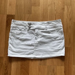 Jeanskjol  - Vit lågmidjad jeanskjol med snygg knäppning. Bra skick, använd fåtal gånger.