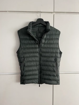 Väst - Säljer min riktigt snygga massimo dutti väst då den e för liten, storlek S, mörk grön färg i hybrid. Baksidan är tyg och framsida dun. Minimal fläck vid bröst, syns knappt vid användning. 