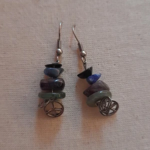 Örhängen  - Örhängen som har kristaller på sig och ett peacemärke färgerna svart blå lila och grön