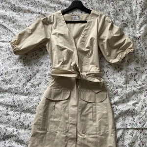 Klänning - Beige kortare klänning från Nakd i strl 34. Använd fåtal gånger och i fint skick, priset är 120 kr + frakt