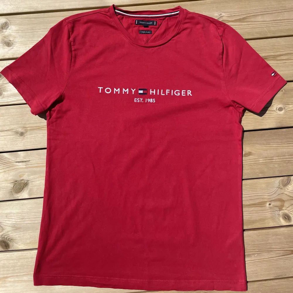 Tjena! Säljer en snygg, röd Tommy Hilfiger T-shirt i storlek L. T-shirten  är använd MAX en gång och är i utmärkt skick✅. T-shirts.