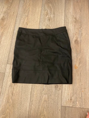 Läderkjol - Ej riktig läder!  Denna kjol är supersnygg och har dessutom fickor! + supermjukt innertyg. Köpt second hand, använd 1 gång av mig. Tyvärr för stor.