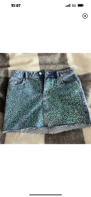 Kort jeanskjol  - Kort & tight jeanskjol från h&m med paljetter på i strl 34💕STRETCHIG🤍 Jag är 171 cm lång! Går att ha både lågmidjat elr högmidjat beroende på preferens. Inga defekter alls!🥰