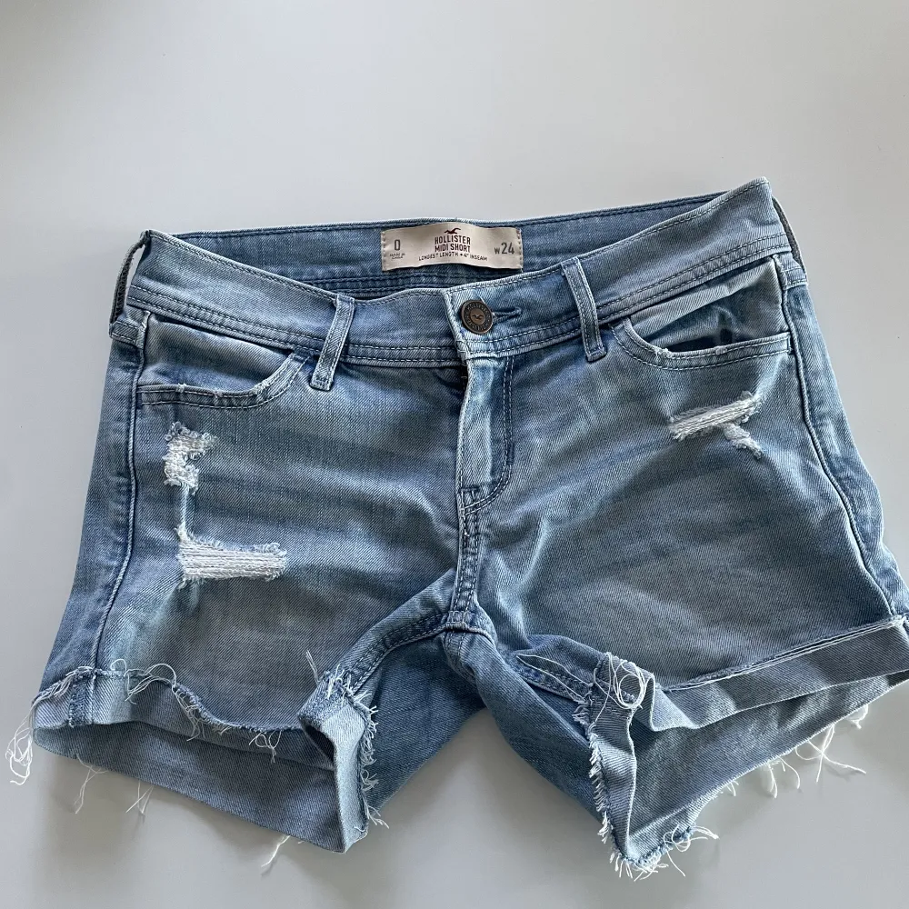 Blåa lågmidjade jeansshorts från Hollister med snygga detaljer på fickorna. Fint skick och storlek W24💕. Shorts.