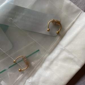 Säljer två stycken helt nya fake septum piercings! De är i obruten förpackning. Guldfärgade, magnet funktion. Köp en för 40kr eller bägge för 60kr! 
