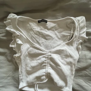 Vit topp med volang - Säljer denna fina somriga toppen från zara! Passar både s och m